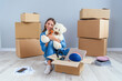 © gorynvd - Beautiful smiling girl puts on the headphones on the teddy bear toy and sitting on the floor in the empty new apartment.