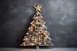 Fancy alternative christmas tree with star made of wooden planks and festive garland on grey background. Sustainable Christmas and new year, zero waste, eco friendly concept