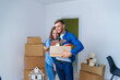 © gorynvd - Young happy family with cardboard boxes opening door of their new home and coming in at empty flat.