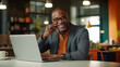 © bmf-foto.de - afro american businessman talking on cell phone while sitting at his laptop in the office