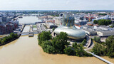 Fototapeta Krajobraz - Aerial view of the Cité du Vin, the Wine Museum of Bordeaux in France - Modern discovery center dedicated to oenology and viticulture built with glass and metal on the banks of the river Garonne