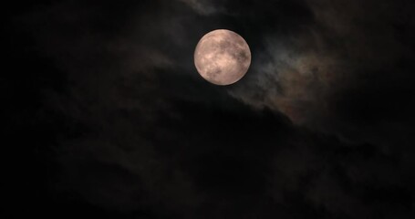 yellow full moon in the cloudy evening sky