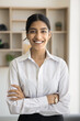 © fizkes - Happy young business professional girl vertical portrait. Confident beautiful Indian businesswoman, office employee, entrepreneur looking at camera with toothy smile, posing with hands crossed