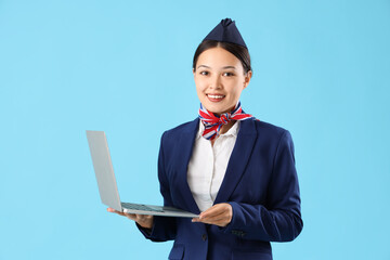 Sticker - Beautiful Asian stewardess with laptop on blue background