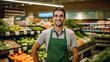 © RCH Photographic - Portrait of an attractive smiling young man greengrocer standing in a vegetable and fruit risle retailer selective focus