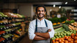 Portrait of an attractive smiling young man supermarket worker standing in a vegetable and fruit risle retailer selective focus