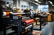 a large printing machine in an office setting with lots of people working on the desks and tables behind it