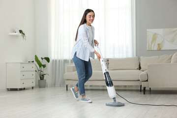 Canvas Print - Happy woman cleaning floor with steam mop at home