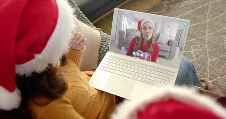 Wall Mural - Happy diverse couple and female friend having christmas laptop video call, slow motion