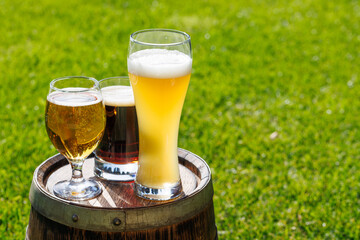 Wall Mural - Variety of beer glasses on rustic wooden barrel