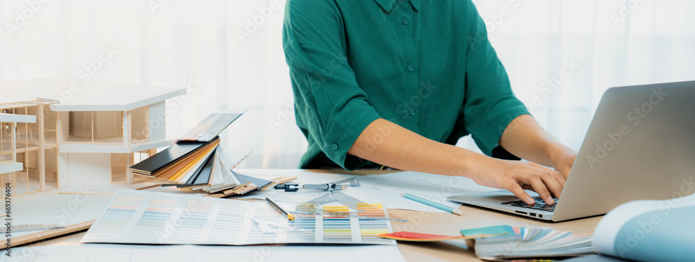Cropped image of professional interior designer using laptop to create ...
