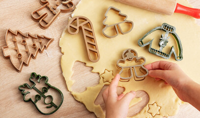 Wall Mural - Children's hands with gingerbread cookies on wooden background