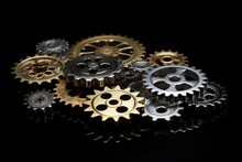 A Mixed Group Of Gold And Silver Gears Of The Same Size, Set Against A Black Background With A White Border. Generative AI