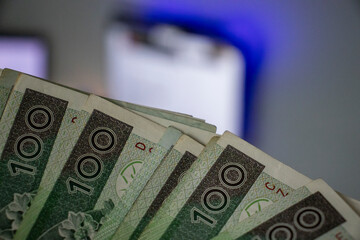  Close-up shot of a hand holding Polish banknote, symbolizing finance and business.