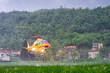 Helicopter emergency medical service taking off from a hospital helipad in heavy rain during a severe thunderstorm
