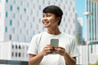 © Prostock-studio - Happy young asian man using smartphone, posing at urban area