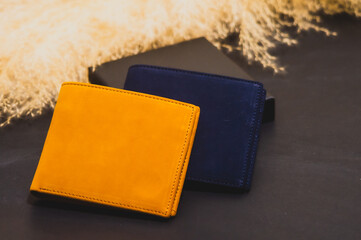 High quality genuine leather wallet in two colors placed on a purple background. Golden dried grass flowers, Studio Shot