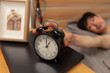 © View Stock - North drift middle-aged man presses alarm clock