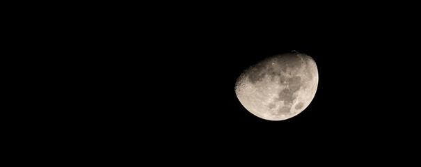 Wall Mural - half moon background. earth's moon glowing on black background. moon on the dark night