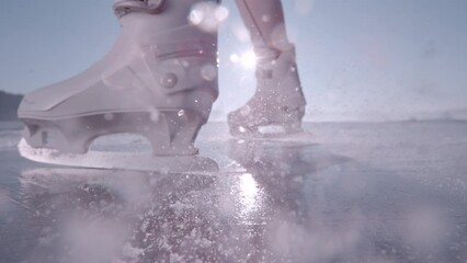 Wall Mural - LENS FLARE, SUPER SLOW MOTION, CLOSE UP: Woman brakes on her skates and ice flies. Unrecognizable woman is skating on sparkling ice surface of a big frozen lake on beautiful sunny and cold winter day