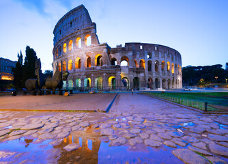 Wall Mural - view of Colosseum with puddle illuminated at night in Rome, Italy, toned