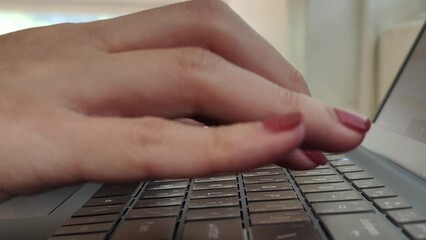 Wall Mural - close up side view of female hands of typing keyboard on laptop at office desk. concept of working o