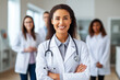 © Katynn - Confident young  female doctor gp wear white coat stethoscope looking at camera standing with arms crossed in medical clinic office. Health care professional medic physician portrait.