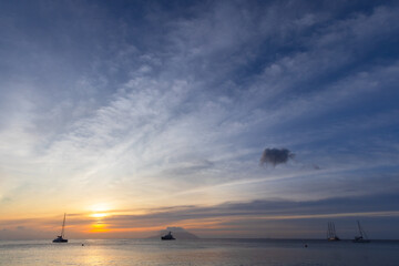 Wall Mural - Seaside landscape with silhouettes of boats under sunset sky. Mahe, Seychelles