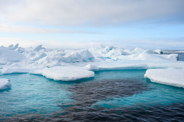 Melting ice at the edge of the ice pack in the arctic ocean, ice bergs floating in the ocean in the far north, signs of global warming and climate change
