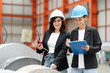 © Montri - two professional woman engineer,worker,technician use clipboard discuss work, walk in steel metal manufacture factory plant industry. woman wear hard hat check quality machine