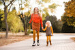 © morrowlight - Two kid girls run in autumn park outdoor together. Friendship. Fall season. Look at camera.