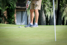 Man Lining Up His Golf Club And Ball To Putt Ball To The Hole On A Golf Course In Central Florida