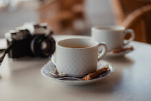 Two Cups Of Coffee And A Vintage Analogue Camera On A Table