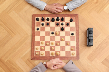 Wall Mural - Men playing chess during tournament at wooden table, top view