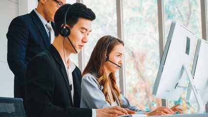 Wall Mural - Business people wearing headset working in office to support remote customer or colleague. Call center, telemarketing, customer support agent provide service on telephone video conference call. Jivy