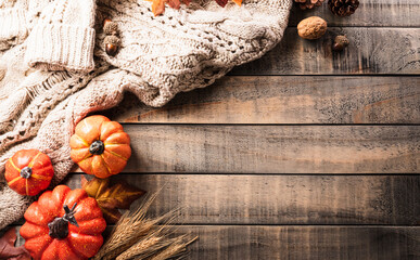 Canvas Print - Autumn and thanksgiving decoration concept made from autumn leaves and pumpkin on dark wooden background. Flat lay, top view with copy space.