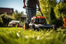 Man Mowing The Lawn With A Lawn Mower In The Garden. Gardening Concep