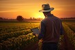 © Thares2020 - Field technology. Farmer using tablet to examine crops in sunset. Rural innovation. Agricultural worker using digital tools in countryside