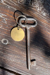 Old key with blank tag wooden background. Space for text. Rustic texture. Retro style. Vintage object