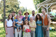 © Halfpoint - Family portrait at outdoor summer garden party. Family and friends standing, posing for a group photo. Multigenerational family.