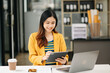 © Nuttapong punna - Successful Asian Businesswoman Analyzing Finance on Tablet and Laptop at Office Desk tax, report, accounting, statistics, and analytical research concept.