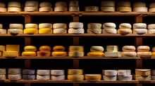 Different Cheeses Stacked On Shelves At A Creamery