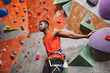 © LIGHTFIELD STUDIOS - good looking african american man with alpine harness posing near climbing wall and looking away