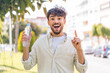 © luismolinero - Young Arabian handsome man with a bottle of water at outdoors pointing up a great idea