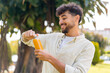 © luismolinero - Young Arabian handsome man holding an orange juice at outdoors