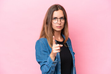 Wall Mural - Young caucasian woman isolated on pink background frustrated and pointing to the front