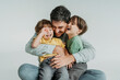 © Westend61 - Happy father having fun and hugging children against white background