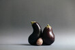 © Westend61 - Eggplants and single gooseberry against gray background