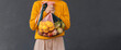 Woman holding fresh fruits in mesh bags against black background