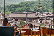 대한민국 서울 은평구 은평한옥마을에 있는 카페에 앉아 있는 여자와 창문 밖으로 한옥마을이 보이는 풍경